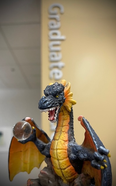 the procrastination dragon below the word graduate